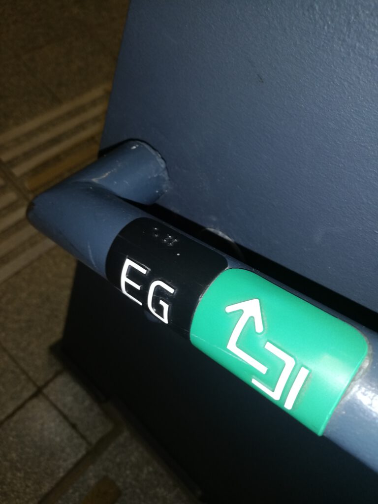 Stiegengeländer mit Aufschrift "EG" in Braille und lateinischer Schrift